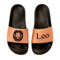 Black slides with tan straps featuring a lion logo and 'Leo' 
